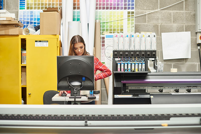 female printing professional using a digital printing machine