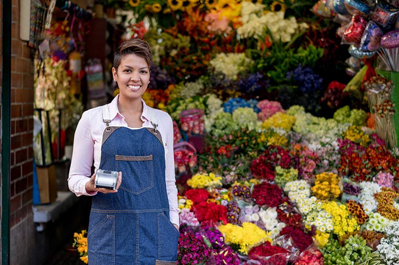 young florist in front of a colorful flower display