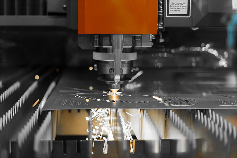 laser engraver creating designs on steel sheet