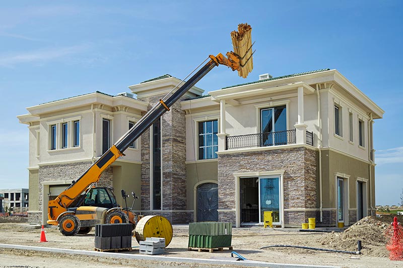equipment lifting materials to the roof of a new home