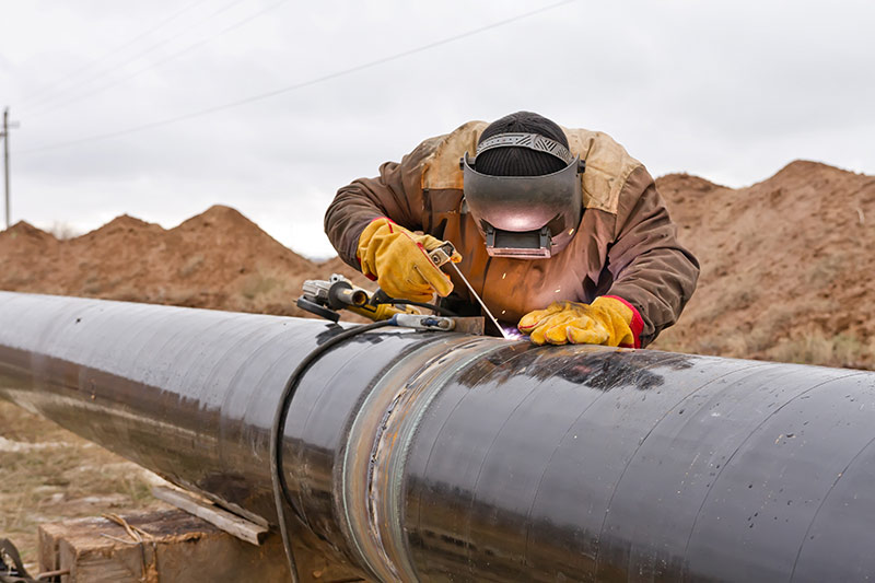 professional welder working on a large pipe