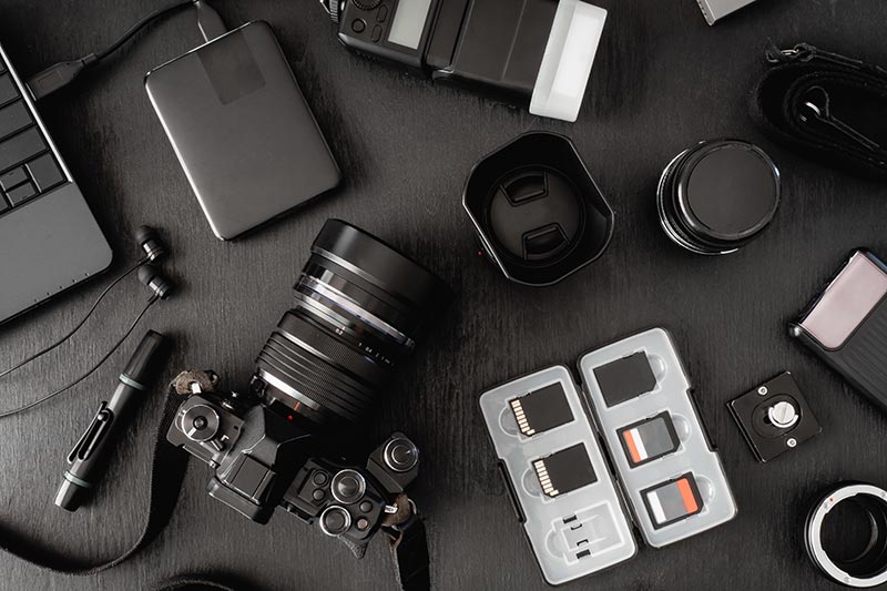 assorted photography equipment on a dark table
