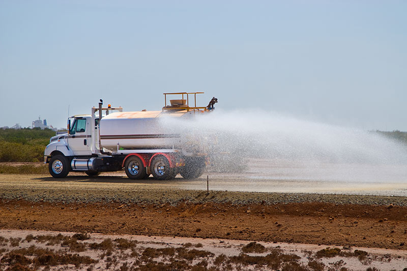water truck spraying water at a new construction site