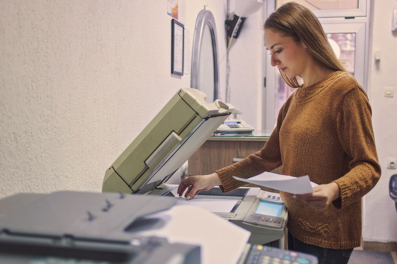 female worker making copies on an office products machine