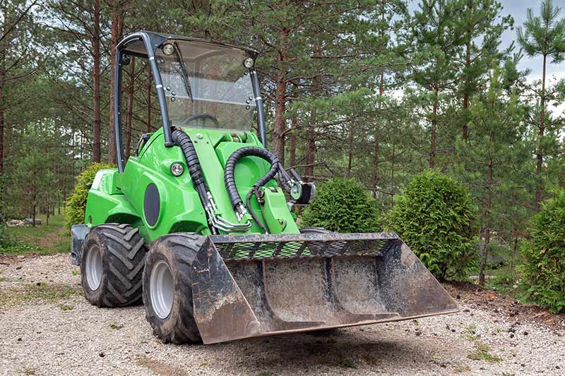 green skid steer at a construction site