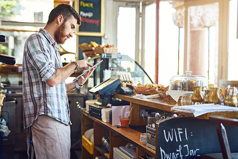 male cafe employee using a mobile tablet