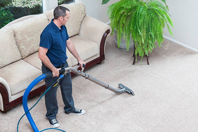 man cleaning carpet at a nice home