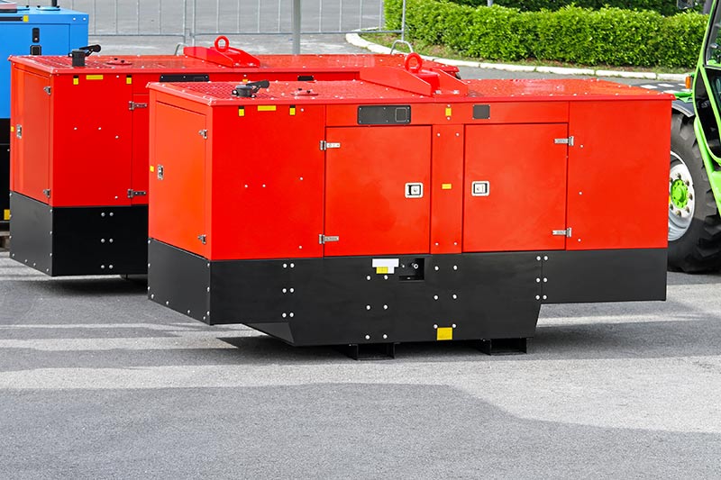large red and blue power generators at a job site