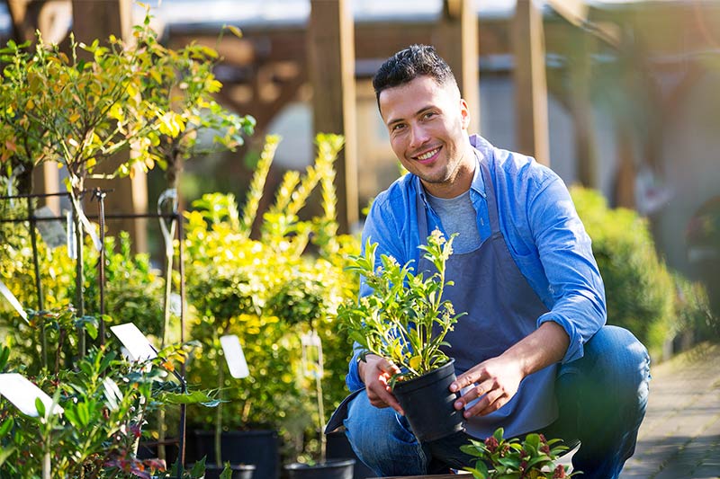 garden store business owners smiling next to plants