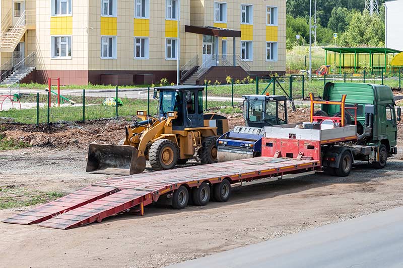 lowboy trailer at a construction site