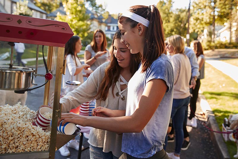 teenagers buying popcorn at a community popcorn stand