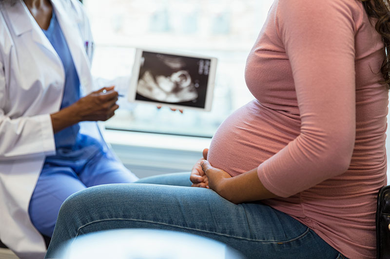 physician and pregnant woman next to an ultrasound machine, ultrasound machine financing