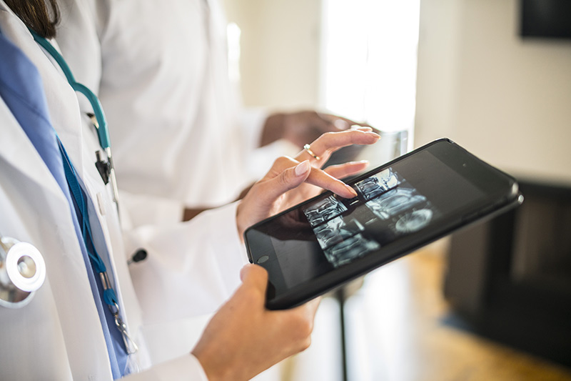 physicians looking at radiology scan on a tablet, pacs financing