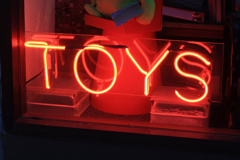 red neon toy store sign in a window
