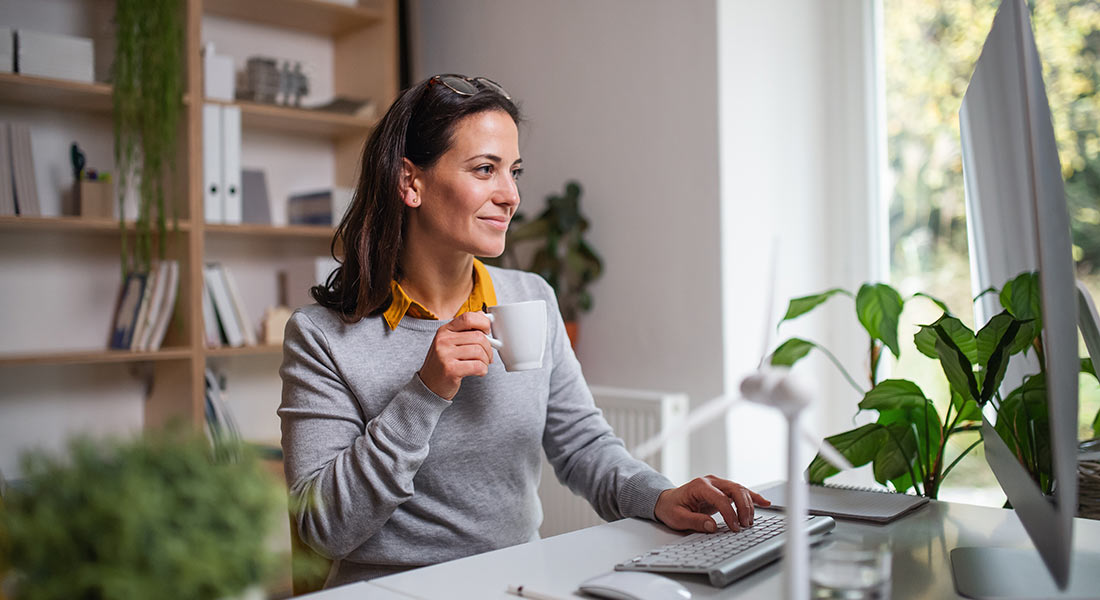 female business owner smiling at her desk, benefits of having plants in the office