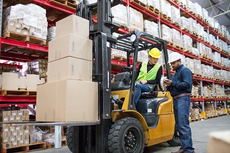 two warehouse workers near forklift, warehouse equipment financing