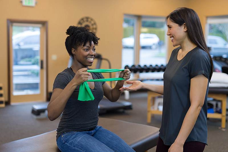 female physical therapist working with a female patient with stretching exercises