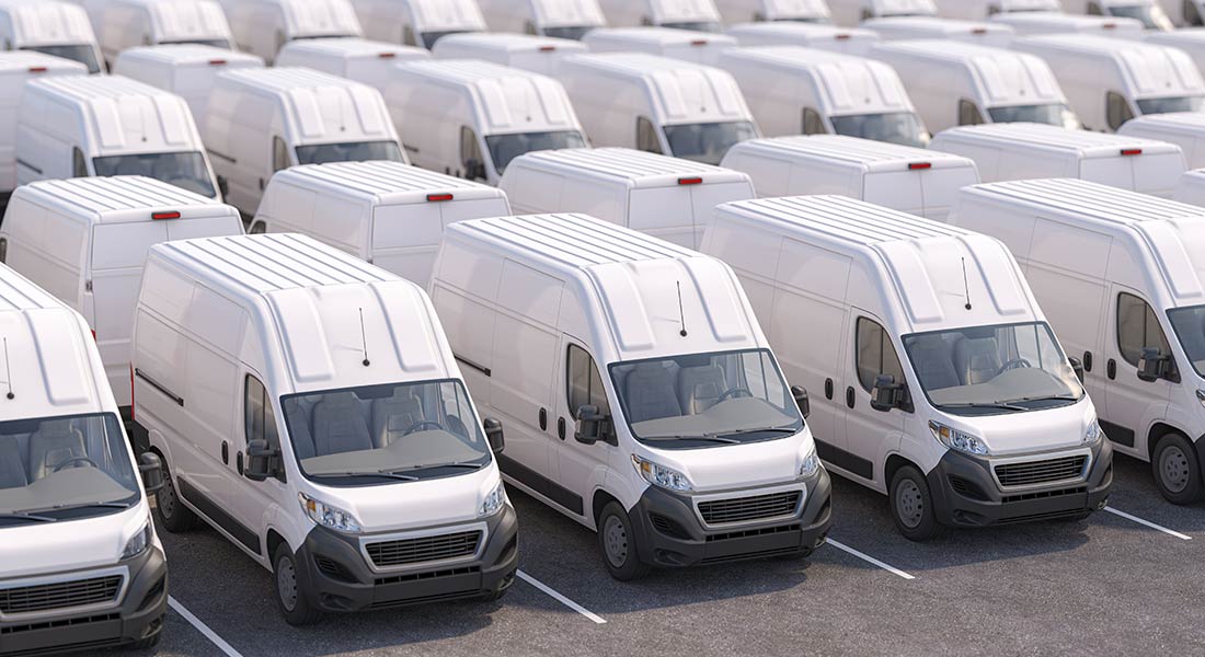 rows of new commercial vehicles and vans on a lot, fleet financing guide