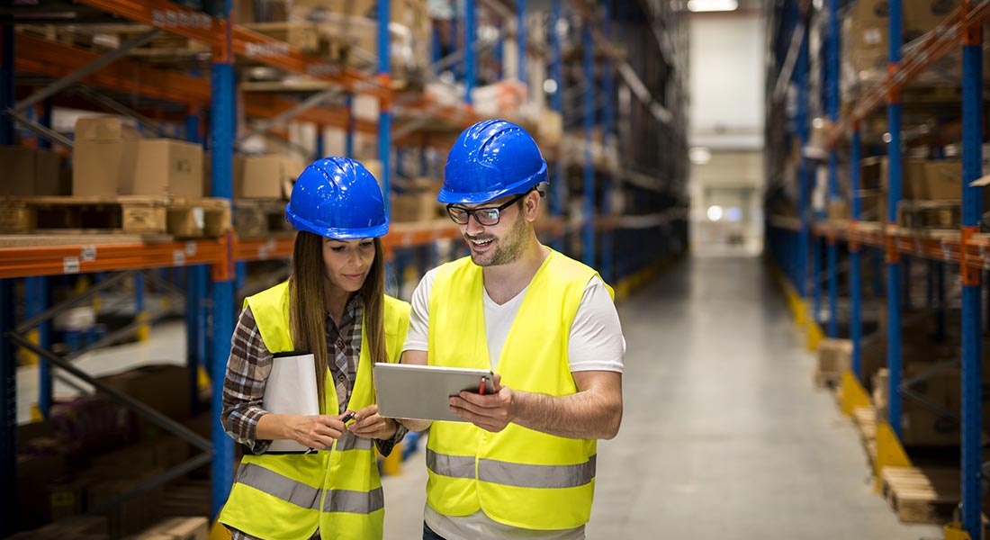 two warehouse managers discussing a task next to inventory, warehouse optimization tips