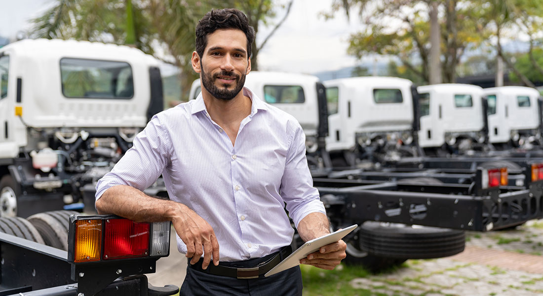 commercial vehicle vendor sales manager smiling in an outdoor sales lot, six new year’s resolutions for equipment vendors